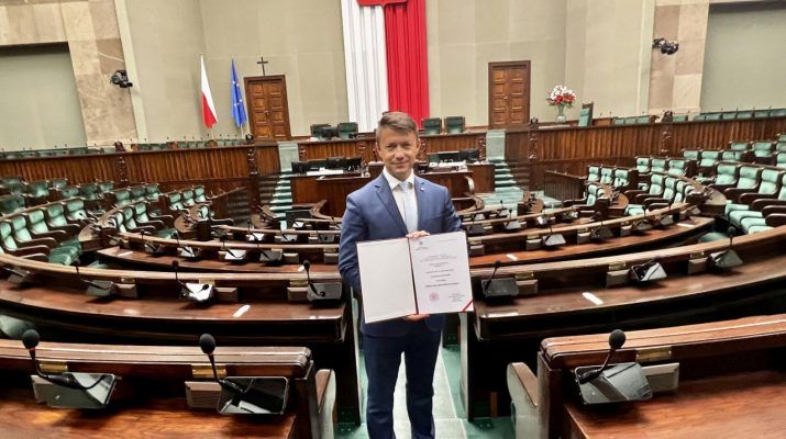 Bartłomiej Dorywalski prezentuje zaświadczenie o wyborze na posła na Sali Plenarnej Sejmu (fot. Bartłomiej Dorywalski).